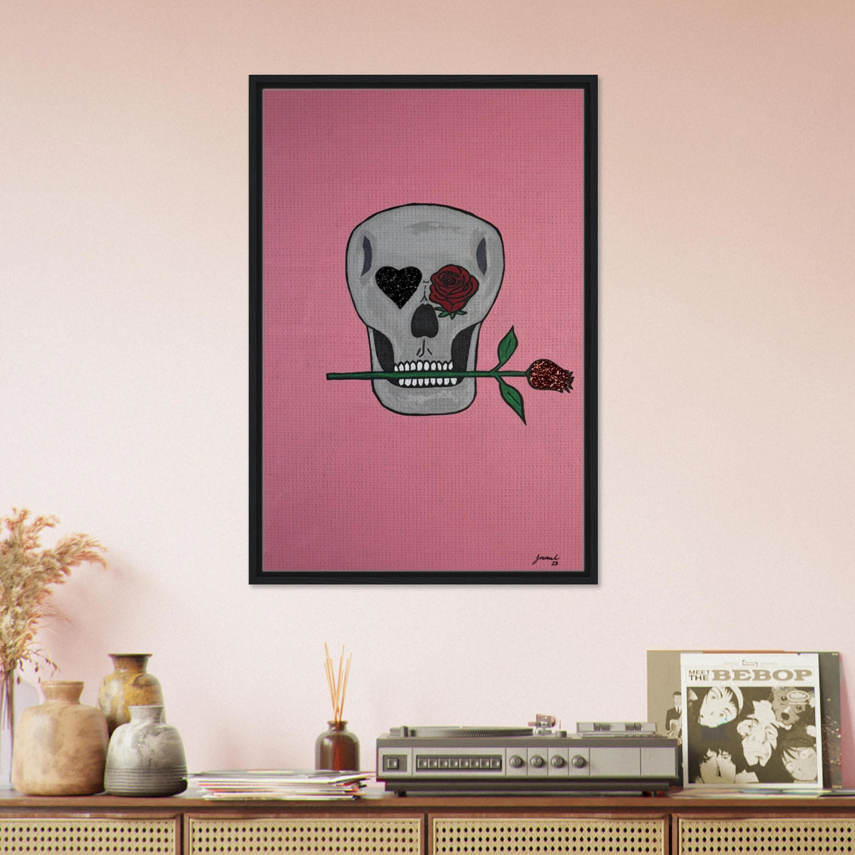 Framed 24×36 Johnny X canvas showing a gray skull on pink field, one eye a black heart, the other a red rose, a rose between its teeth.
