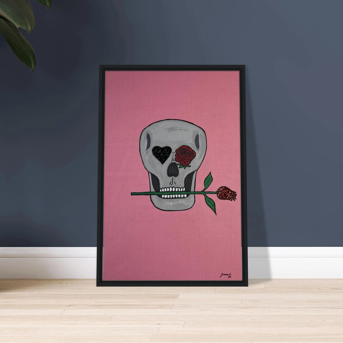 Framed 24×36 Johnny X canvas showing a gray skull on pink field, one eye a black heart, the other a red rose, a rose between its teeth.