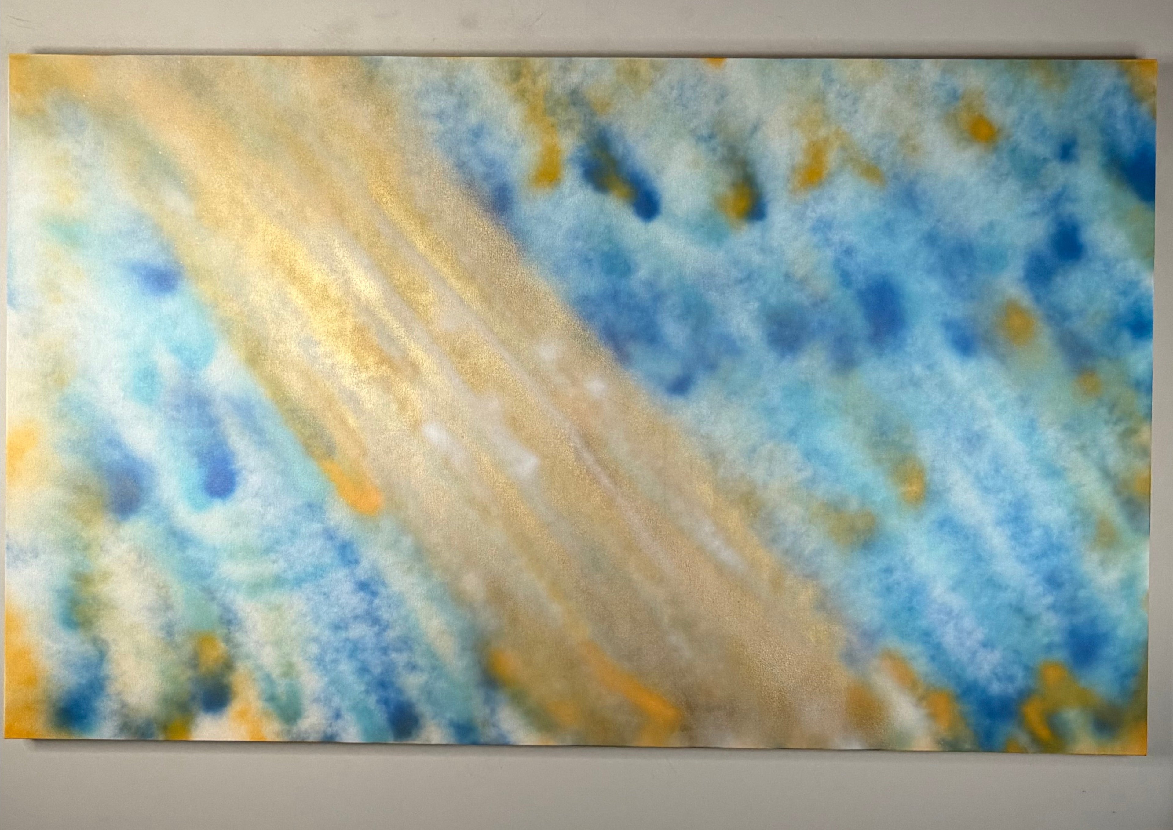 Johnny X’s Inefable, a 30 × 60-inch abstract spray-paint work featuring atmospheric layers of celestial blue and luminous gold, evoking light, movement, spiritual revelation, and an encounter with the divine beyond words.